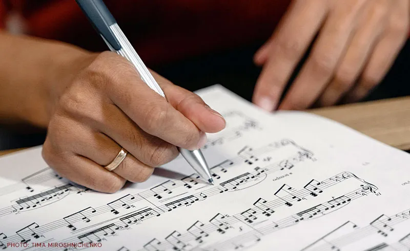 Mucisian writing on a music sheet